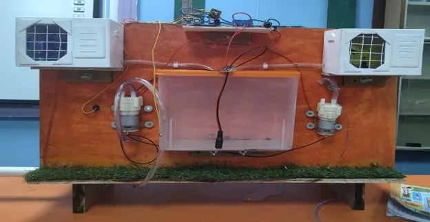 HydroSense water-reuse prototype with tubing, pumps and collection container on a display board